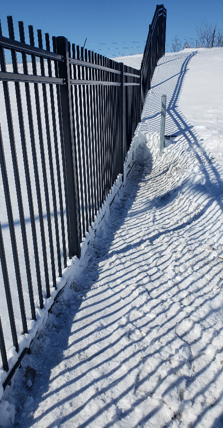 An ornamental gate and fence caked in snow