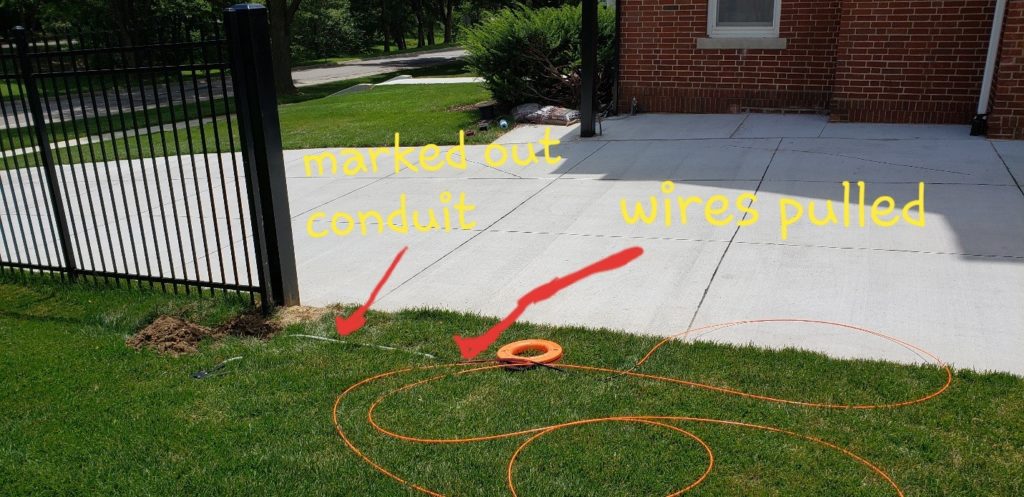A completed driveway with marks shown of where the conduit and pulled wires lay