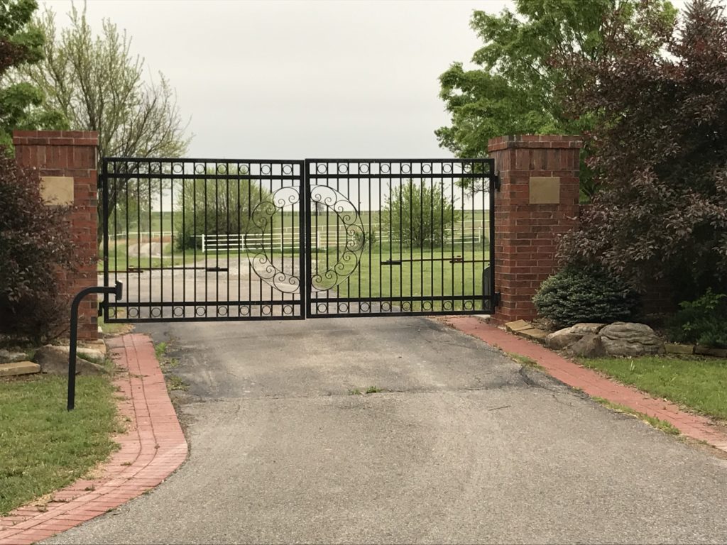 Ornamental automated swing gate installed in front of a driveway with keypad access
